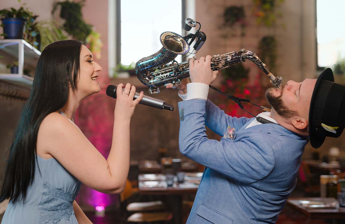 Live Musik für Euer Event – Sängerin und Saxophonist in leidenschaftlichem Bühnenmoment